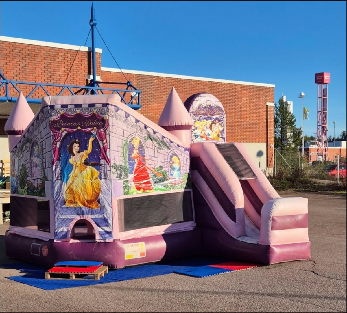 Prinsessalinna-pomppulinna vaaleanpunaisilla ja violeteilla väreillä, täynnä prinsessateemaisia koristeita